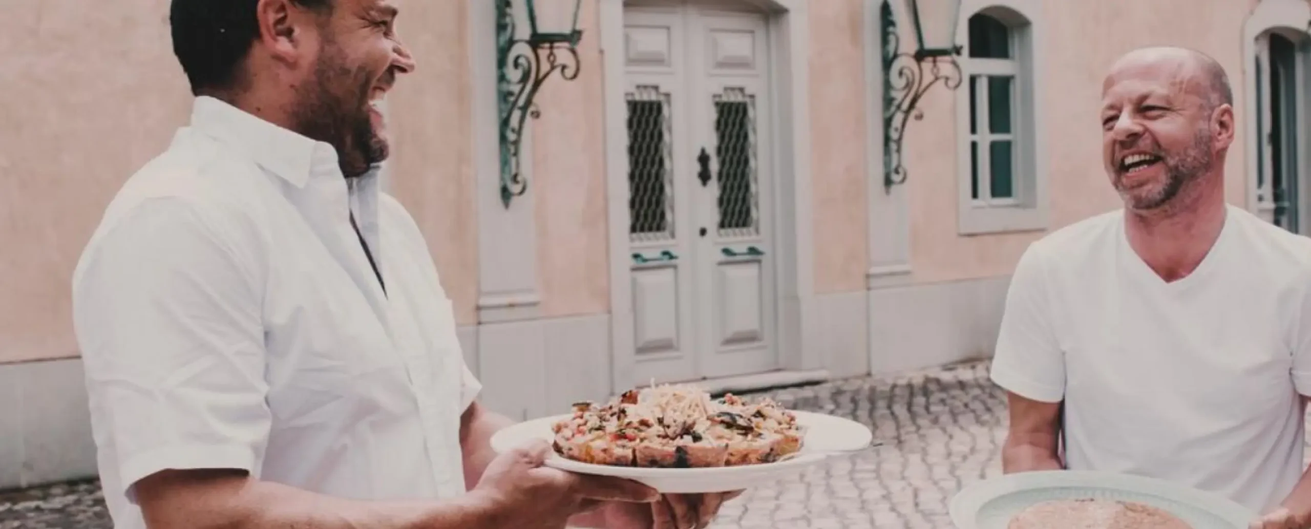 Chef's Nick and James carrying plates of delicious food