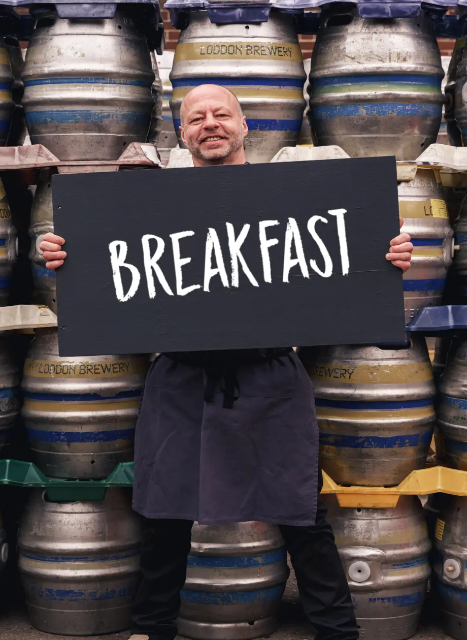 Nick Chef holding up breakfast menu board